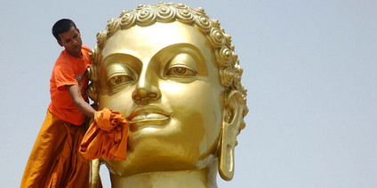 Buddhas Geburtstag: Mönch reinigt Buddha-Statue in indischem Kloster