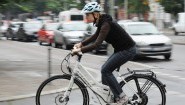 Eine Frau bewegt ein Elektrofahrrad durch Berlin. Die Deutschen nutzen zum Beispiel auf dem Weg zur Arbeit immer häufiger Elektrofahrräder. (dpa / Rainer Jensen)