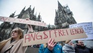 Eine Frau protestiert am 10.01.2016 in Köln vor dem Hauptbahnhof und dem Dom gegen sexuelle Gewalt mit einem Plakat "Angstfrei leben".  (picture alliance / dpa / Maja Hitij)