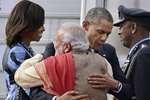 Prime Minister Narendra Modi hugs visiting US President Barack Obama as first lady Michelle Obama looks on upon their arrival at Air Force station Palam, in New Delhi.