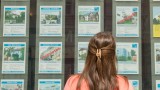 Ein Frau steht in München vor dem Büro eines Immobilienmaklers (dpa / picture alliance / Peter Kneffel)