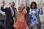 Prime Minister Narendra Modi with visiting US President Barack Obama and first lady Michelle Obama wave upon their arrival at Air Force station Palam, in New Delhi.